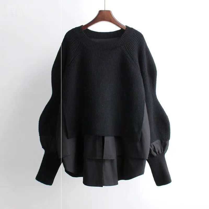 Black sweater on a hanger against a white background