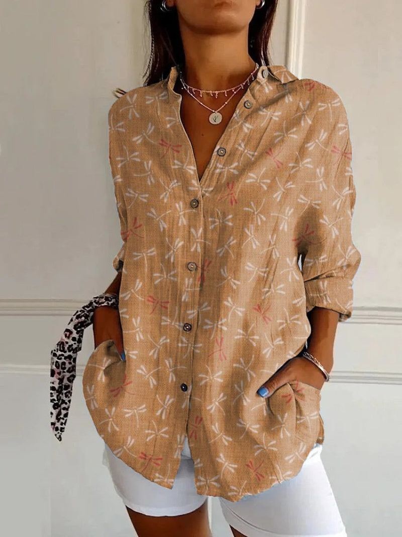 Woman wearing a beige patterned shirt with a white background