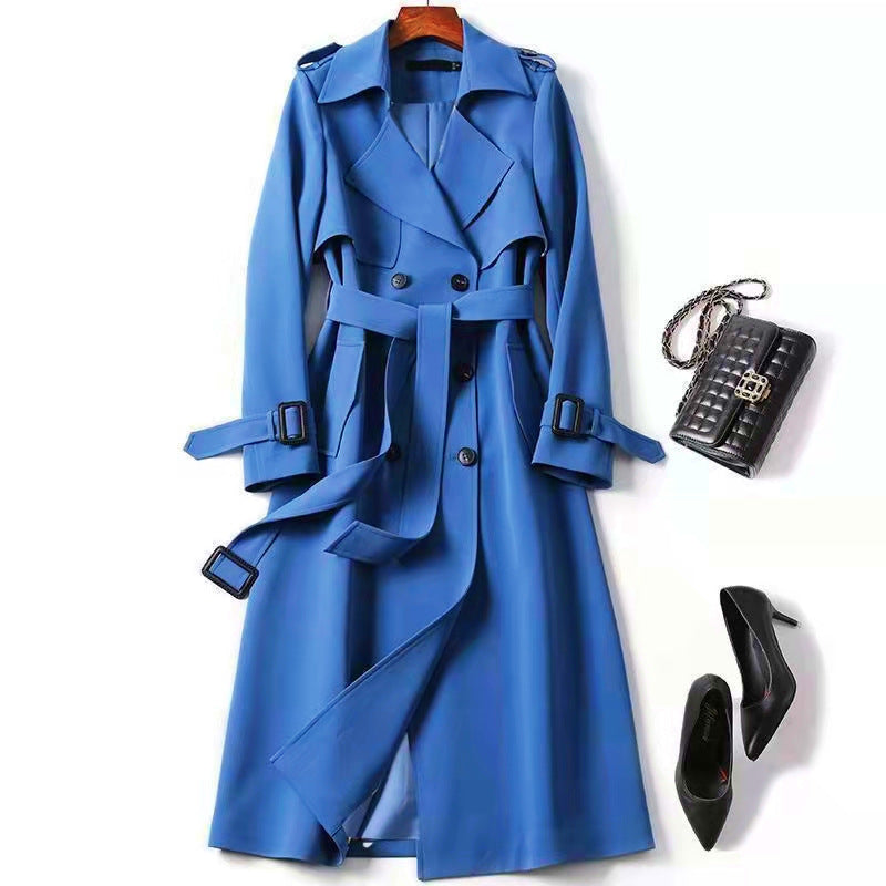 Blue trench coat with black handbag and high heels on a white background
