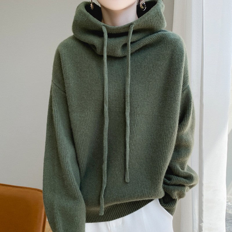 Green hoodie worn by a person against a neutral background